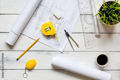 engineering tools on wooden table with drawings apartments top view