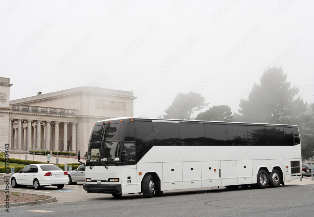 Tour charter bus parked outside of San Francisco's Legion of Honor with morning mist and fog. Horizontal.