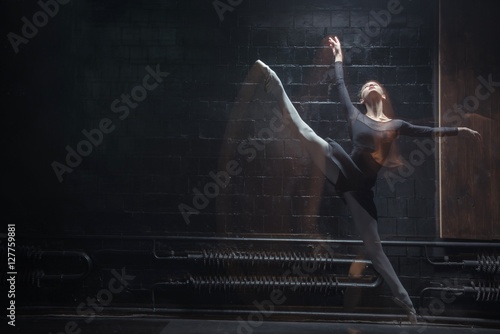 Young gymnast jumping in the twine in the dark room