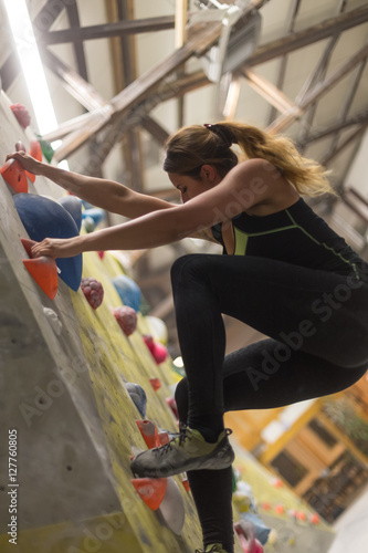 sporty woman in boulder climbing hall