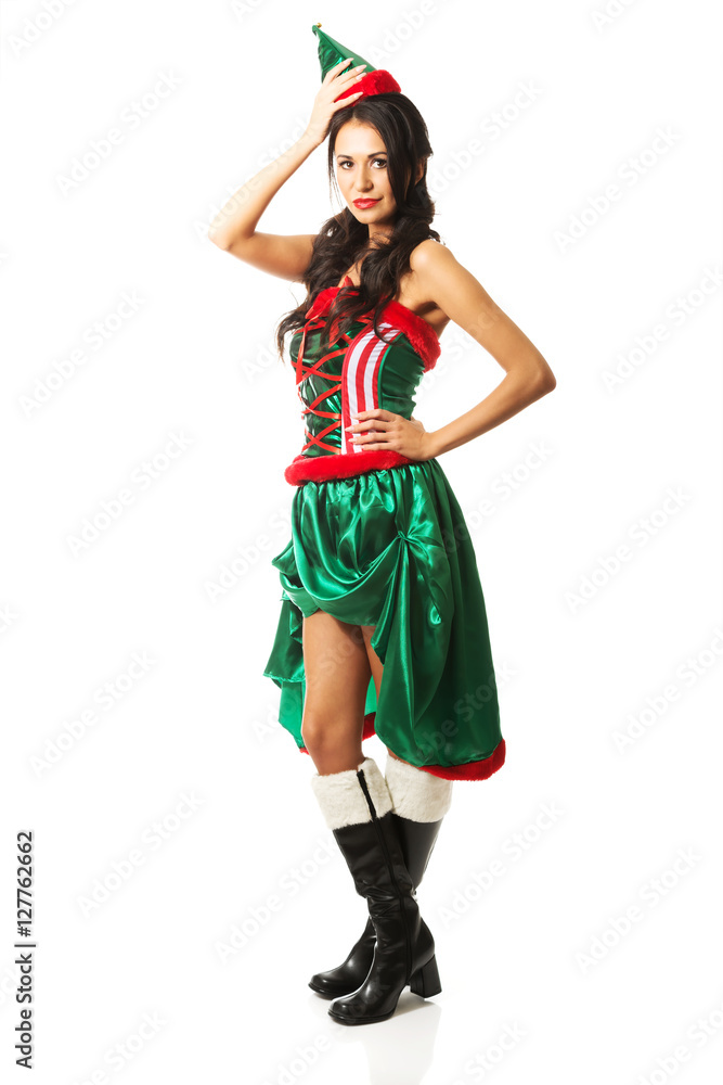 Full length woman wearing elf clothes, touching her head and hip Full length woman wearing elf clothes, touching her head and hip