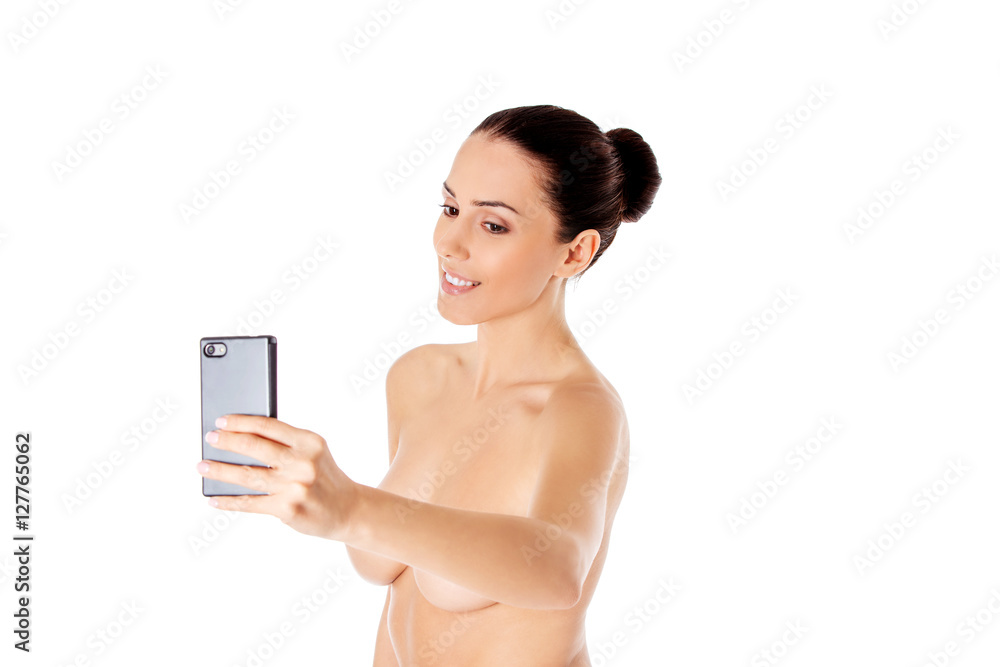 Nude beautiful woman taking selfie on white background. Nude beautiful woman taking selfie on white background.