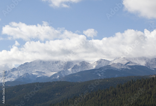Puffy clouds rolling past 14,115 foot Pikes Peak Colorado