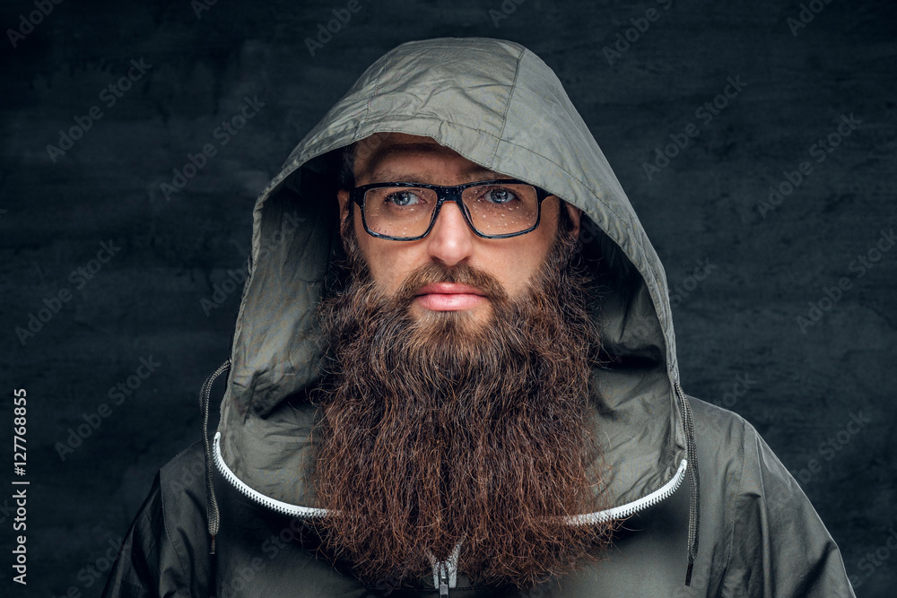 Bearded male in a hood on grey background. Bearded male in a hood on grey background.