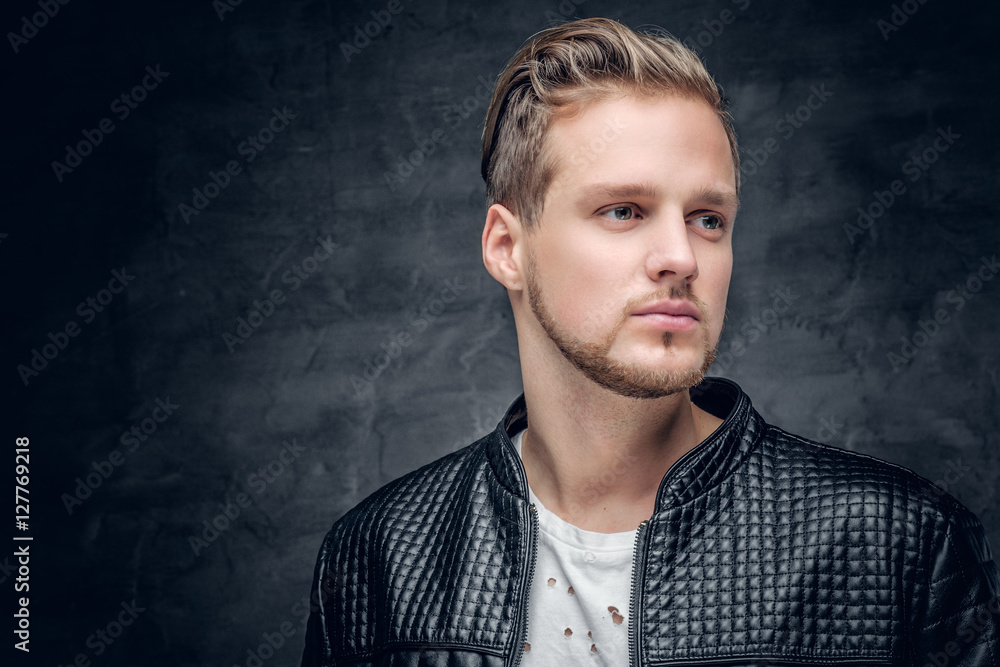 A blond male dressed in a black leather jacket.