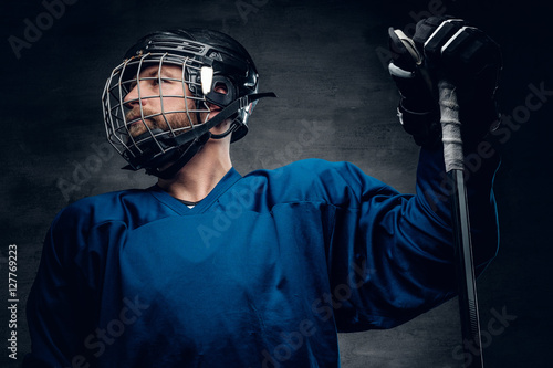 Photography Bearded ice-hockey player in safety helmet holds the gaming stic