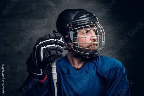 Photography Bearded ice-hockey player in safety helmet holds the gaming stic