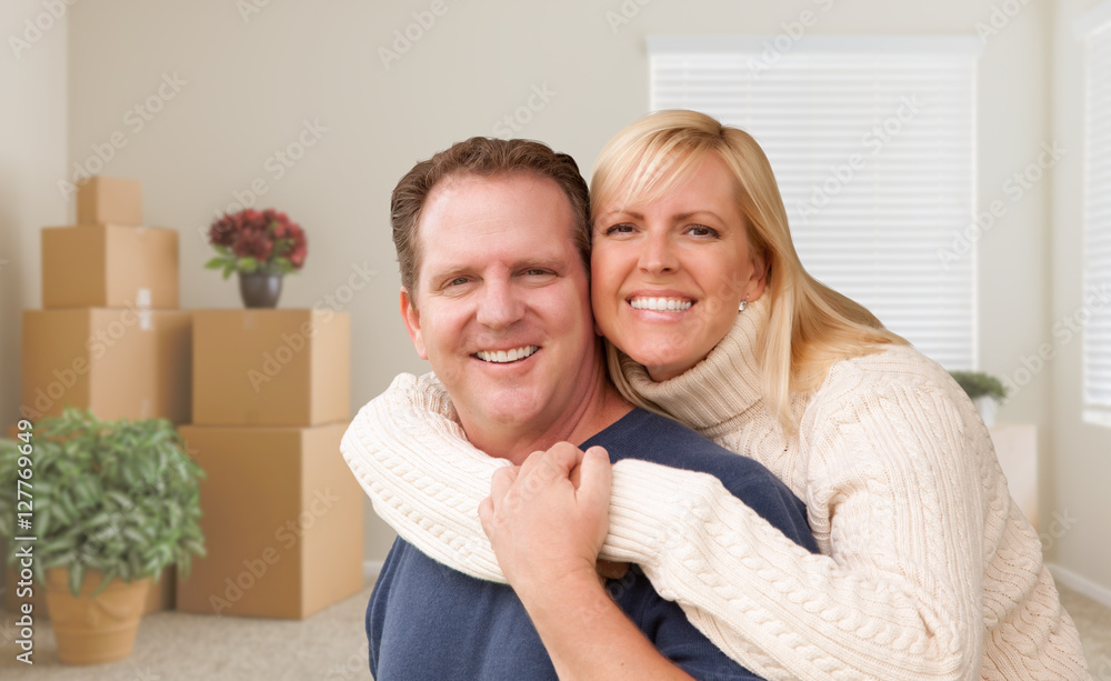 Happy Young Couple in Empty Room with Packed Boxes and Plants. Happy Young Couple in Empty Room with Packed Boxes and Plants.
