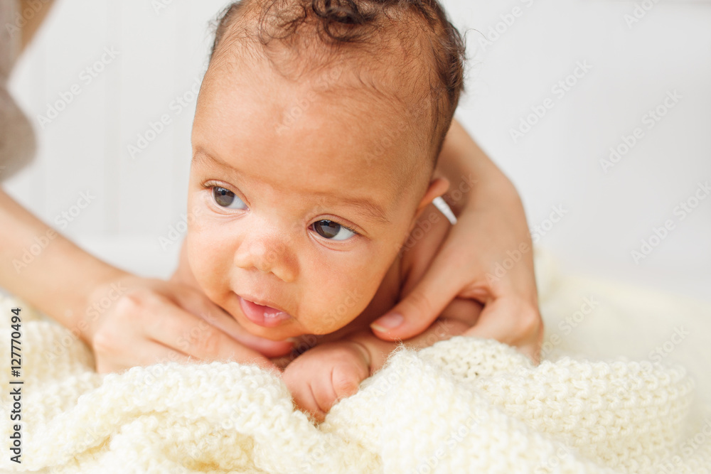 Newborn baby trying to keep head, free space. Close-up of adorable child on woolen blanket lying on stomach, mother help. Newborn baby trying to keep head, free space. Close-up of adorable child on woolen blanket lying on stomach, mother help.