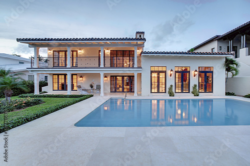 Spectacular Backyard Swimming Pool Designer home. Beautiful Exterior of New Home at Twilight.