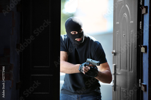 Εκτύπωση καμβά Thief with gun entering the house