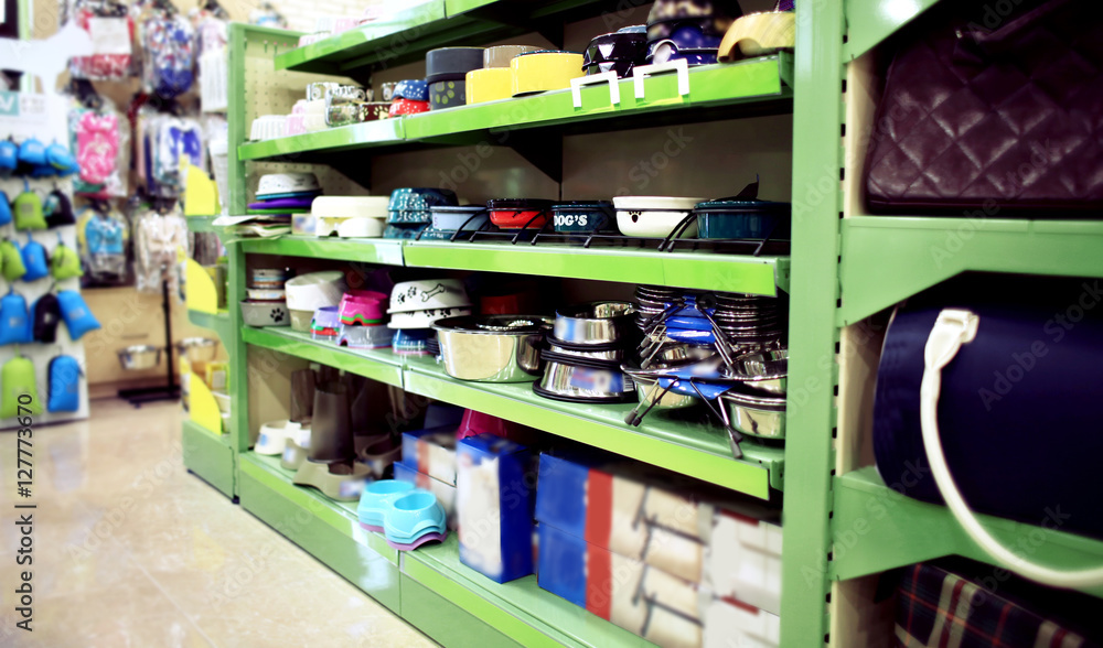 Bags and different colorful bowls on pet shop shelves