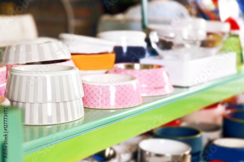 Different bowls on pet shop shelf  close up view