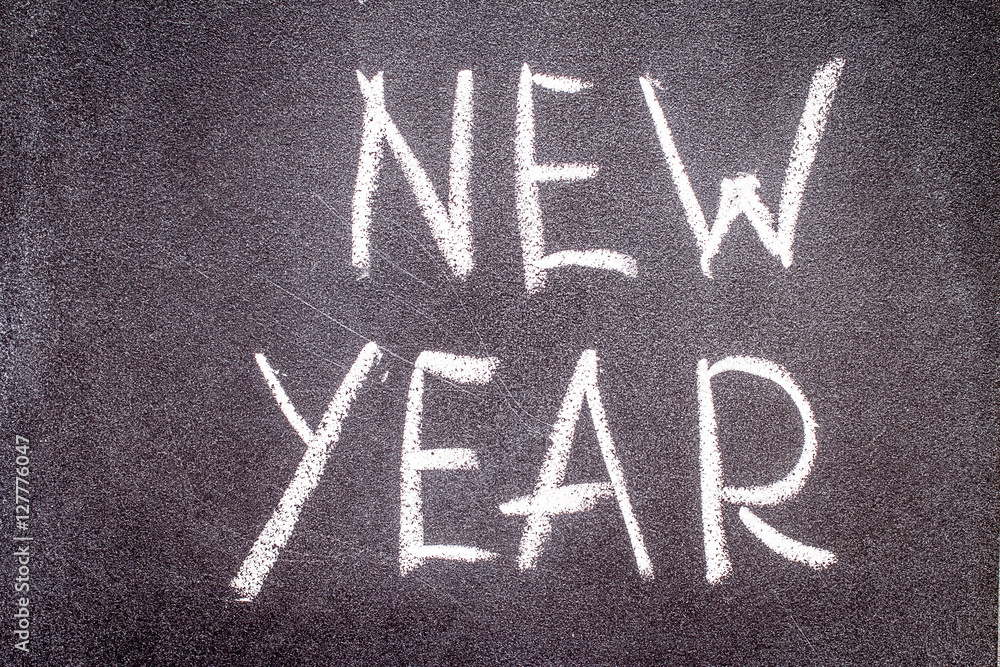 Fototapeta premium New year written with chalk on a black background