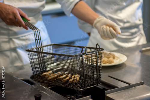Close up Chef cook preparing delicious food fries. Hash Browns being Deep Fried 