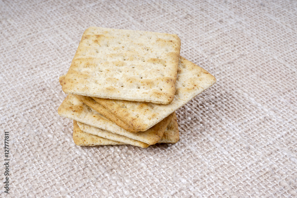 the cream cracker biscuit on the wooden background. the cream cracker biscuit on the wooden background.
