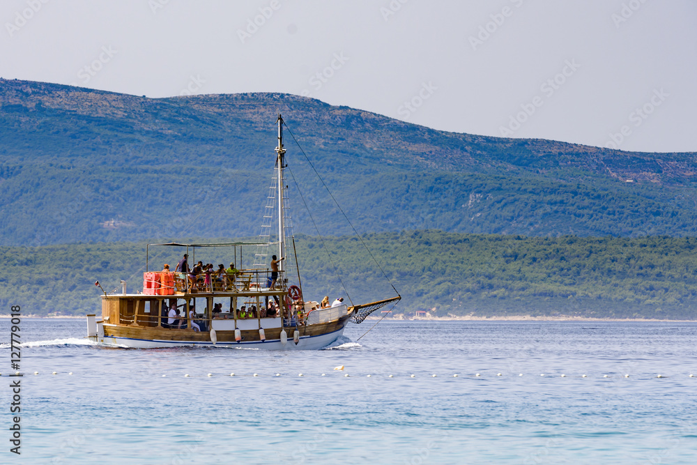 Tourist boat taking guests on sightseeing island tour in Adriati
