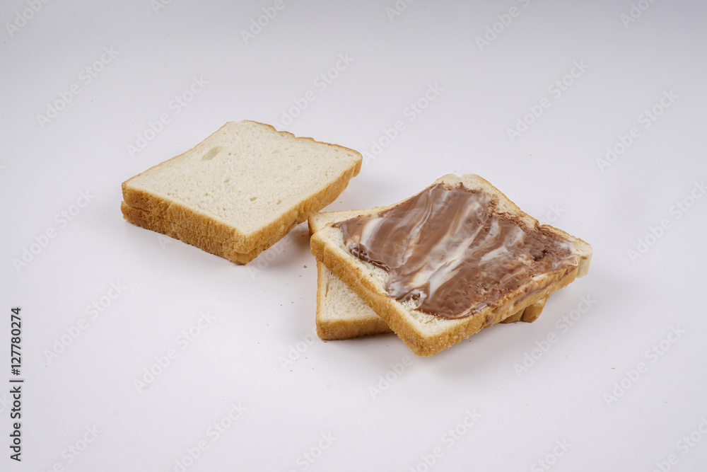 Slice of bread with chocolate hazelnut spread isolated on white
