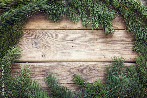 Christmas pine tree branches on old wooden board. Space for text