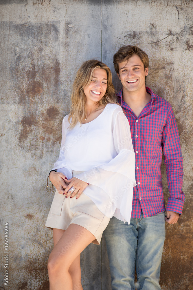 Portrait of smiling young and beautiful couple in the street