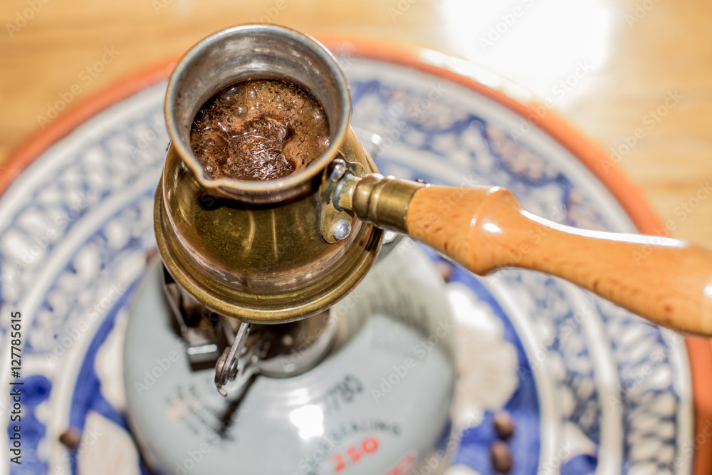 Brewing fresh Turkish coffee pot on portable stove. Brewing fresh Turkish coffee pot on portable stove.