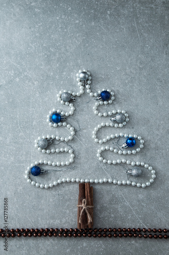 Christmas tree of pearls, cinnamon sticks and Christmas balls. T