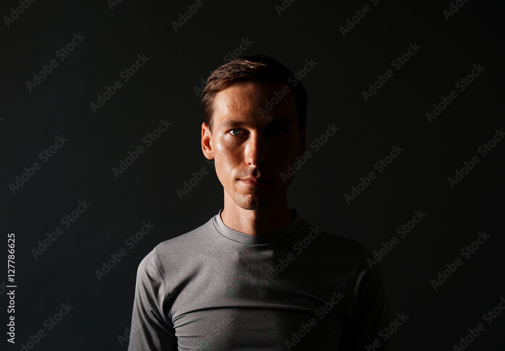 Young man in t-shirt on gray background.