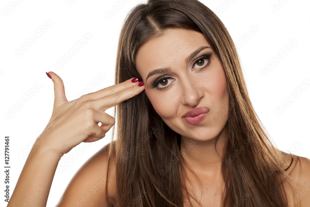 portrait of pretty unhappy woman with fingers like a gun to her head portrait of pretty unhappy woman with fingers like a gun to her head