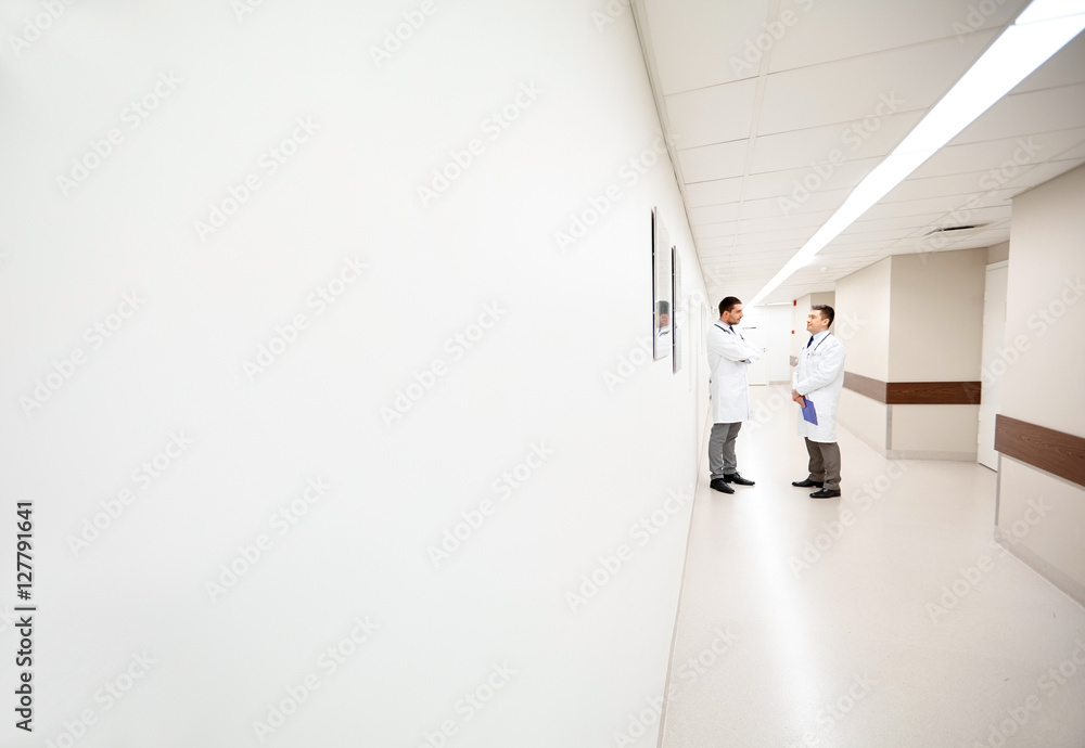 male doctors talking at hospital corridor male doctors talking at hospital corridor