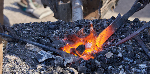 The heating of metal billets on hot coals photo