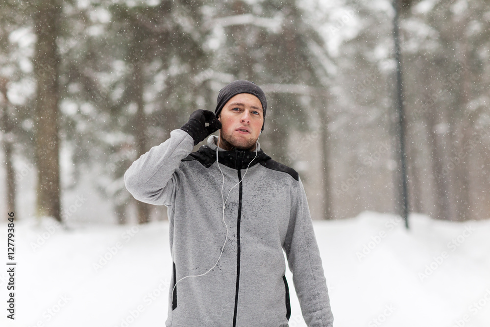 sports man with earphones in winter forest sports man with earphones in winter forest