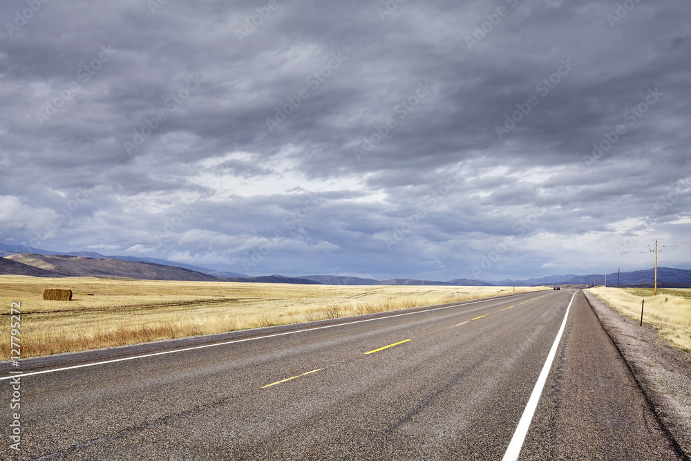 Countryside road with rainy clouds.