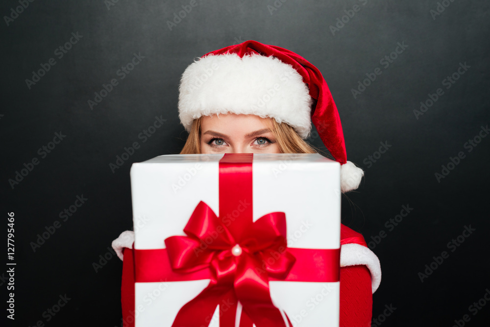 Woman in red santa claus dress giving big gift box Woman in red santa claus dress giving big gift box