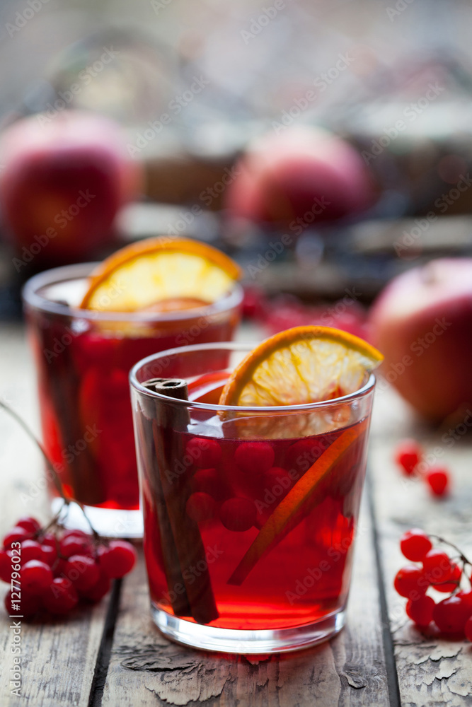 The concept of homemade mulled wine. Sangria or punch with orange, apple and berries in a glass on a wooden table. Creative decoration. The concept of homemade mulled wine. Sangria or punch with orange, apple and berries in a glass on a wooden table. Creative decoration.