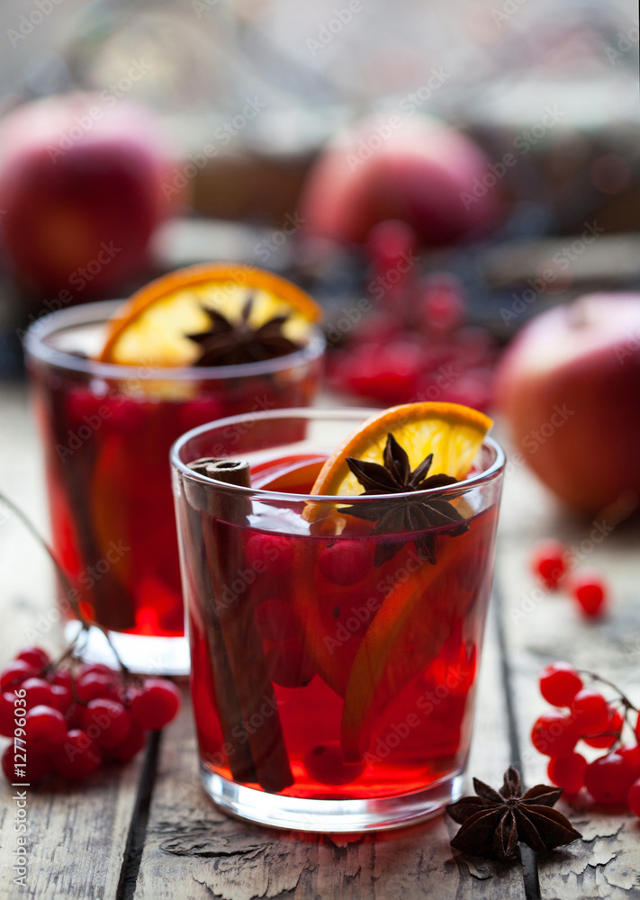 Winter warm drink. Christmas mulled red wine or sangria with cinnamon sticks, anise stars, oranges and berries in a pot on a rustic wooden table Winter warm drink. Christmas mulled red wine or sangria with cinnamon sticks, anise stars, oranges and berries in a pot on a rustic wooden table