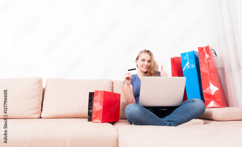 Woman holding laptop and card showing like Woman holding laptop and card showing like
