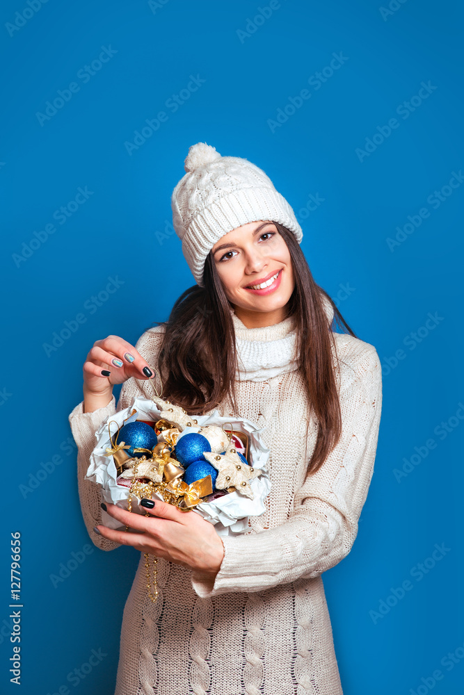 Smiling woman hold box with Christmas decorations. Christmas, x-mas, people, happiness concept - happy woman in winter clothes Smiling woman hold box with Christmas decorations. Christmas, x-mas, people, happiness concept - happy woman in winter clothes