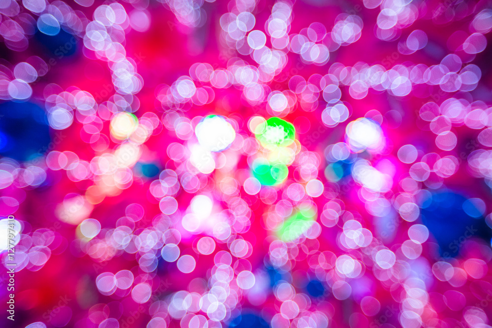 Pink background of bokeh defocused christmas lights from a christmas tree with lights and xmas balls. Pink background of bokeh defocused christmas lights from a christmas tree with lights and xmas balls.