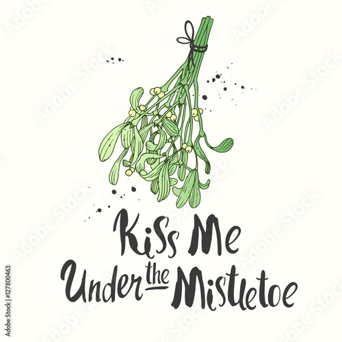 Vector holiday illustration Kiss Me Under the mistletoe on white background with green branch. Handwritten inscription. Lettering design. Sketch style.
