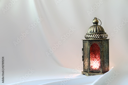 Ancient colored lantern on white satin