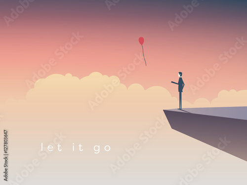 Businessman standing on a cliff letting go  balloon.
