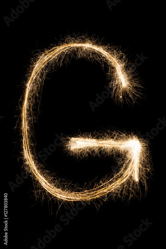 English Letter G from sparklers alphabet on black background.