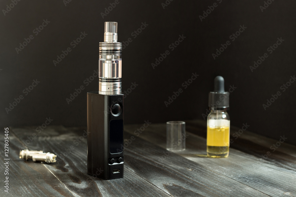 Naklejka premium Vape or e-cigarette. Vaping set on the table.