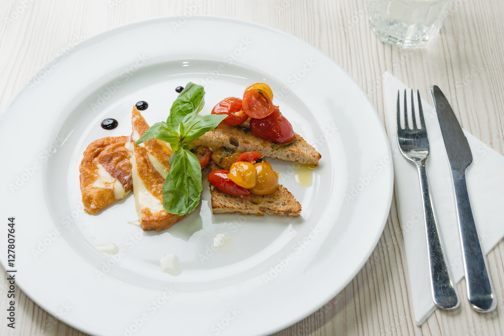 Delicious toast sandwiches with fried cheese, tomatoes, olive oil and basil