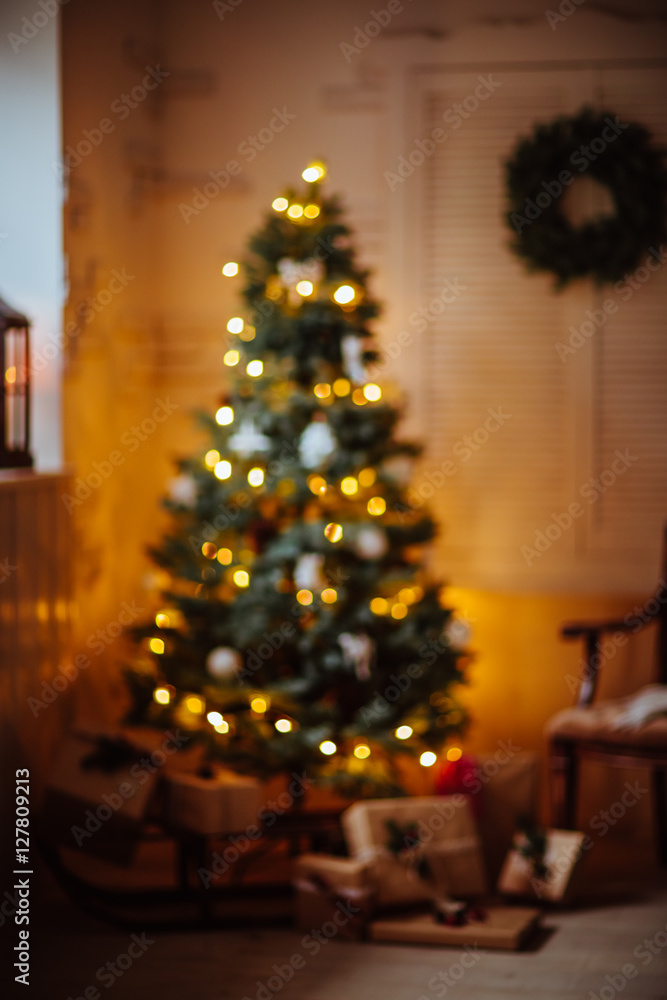 beautiful blurred background Christmas gifts under tree in new year decorated house interior