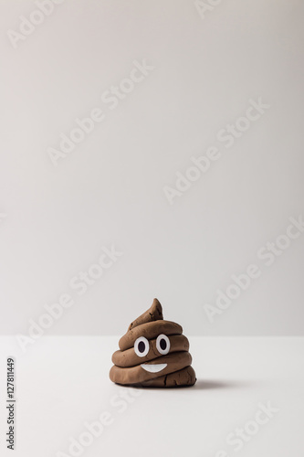 Fotografie Poop emoticon on bright background.