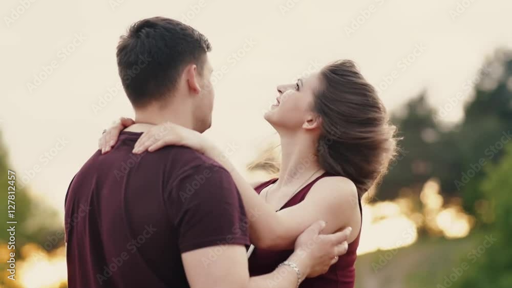 Young lovers stand in front of each other. They smile, man gently touches her hair, woman shakes hair. Slow mo Young lovers stand in front of each other. They smile, man gently touches her hair, woman shakes hair. Slow mo
