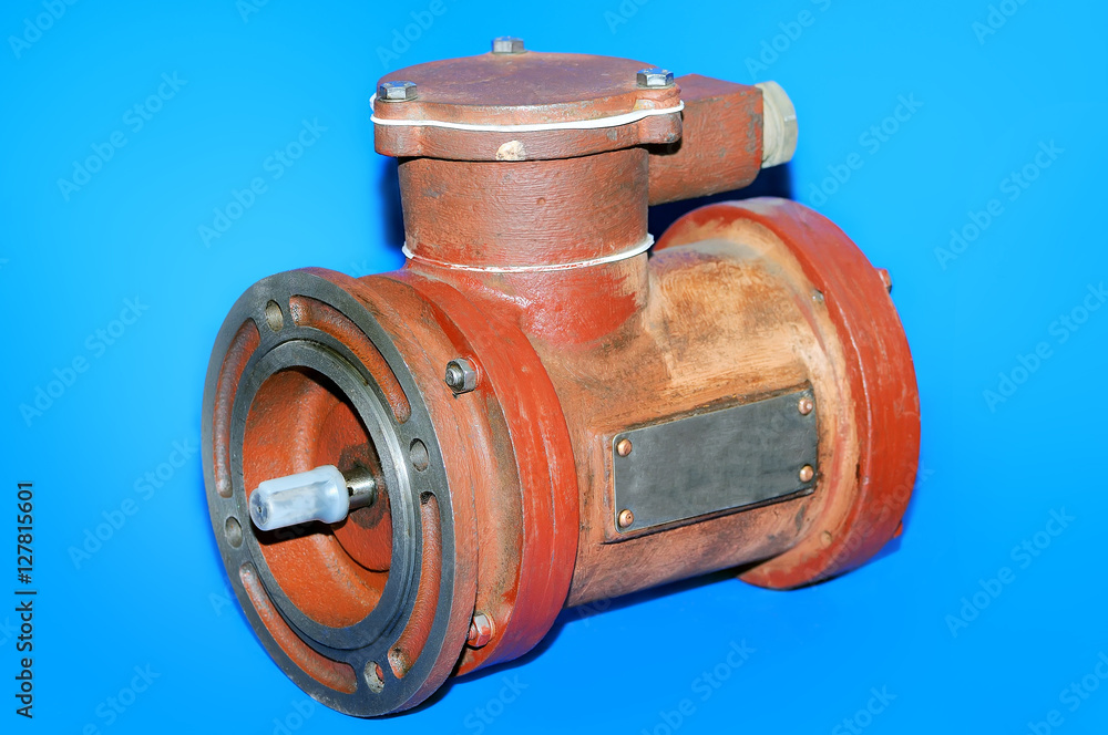 Old red electric motor isolated on a blue background Old red electric motor isolated on a blue background