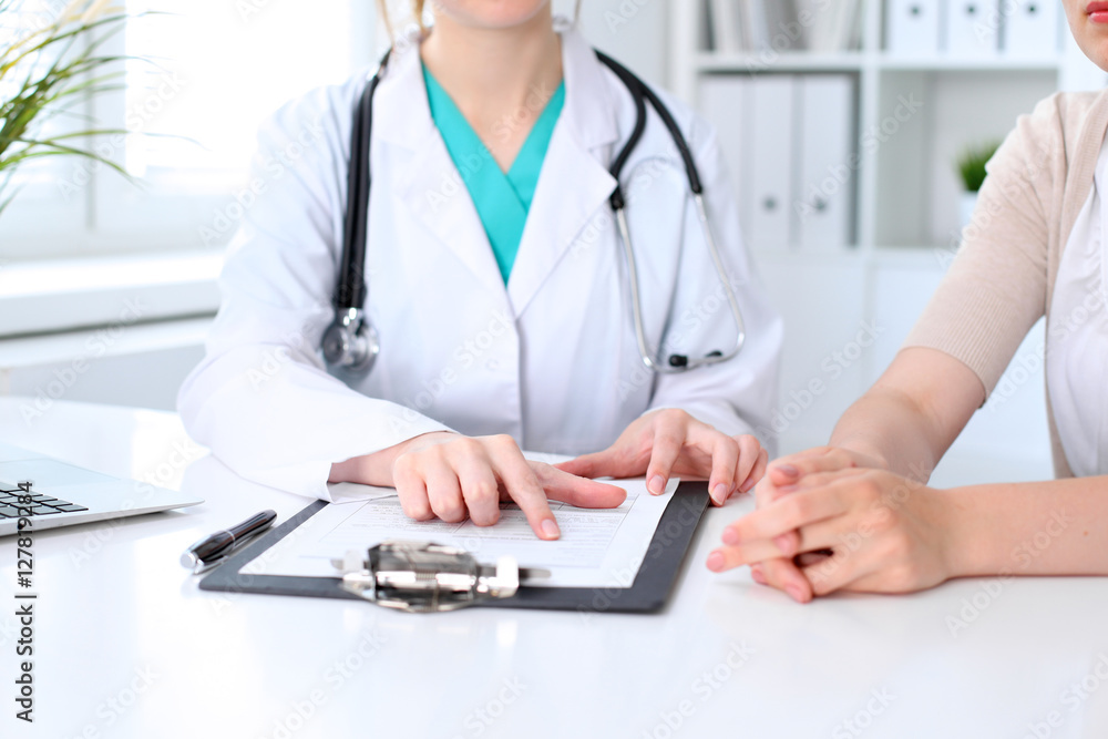 Doctor and patient are discussing something, just hands at the table Doctor and patient are discussing something, just hands at the table
