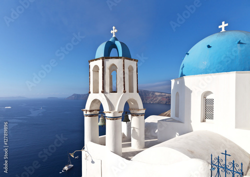 Greece. Santorini Island. The town of Oia. Orthodox Church with the traditional blue domes and white crosses on a background of blue sky and sea